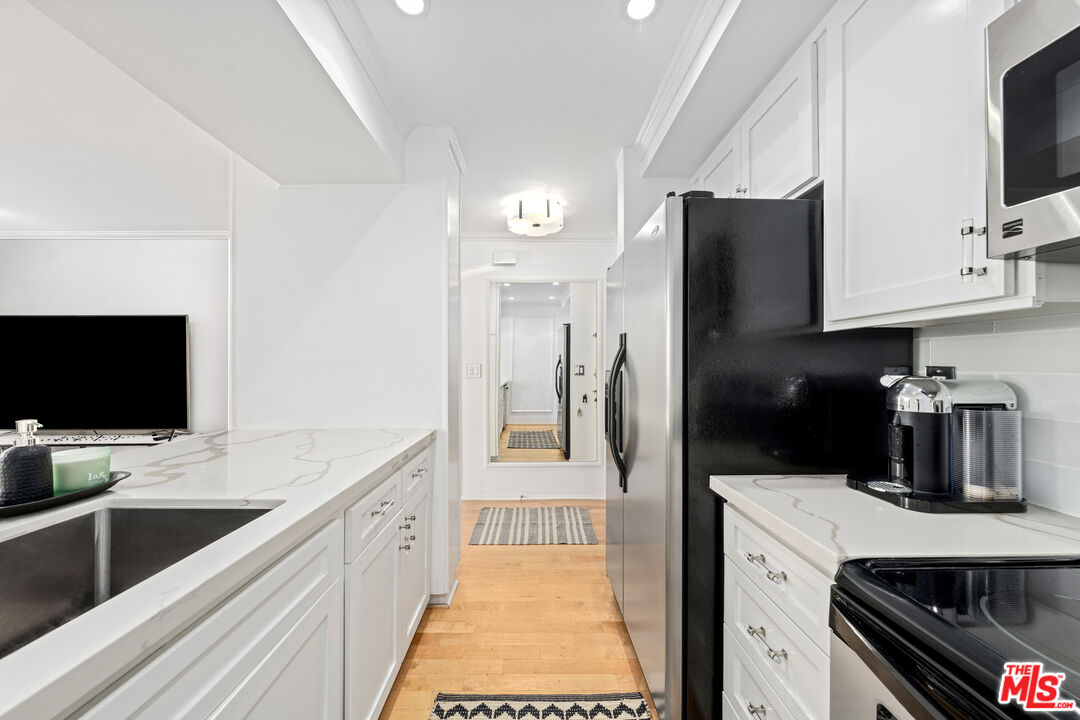 750 North Kings Road, Unit 204 Los Angeles, CA 90069 - Photo 12 of 23 a kitchen with a sink stove and refrigerator