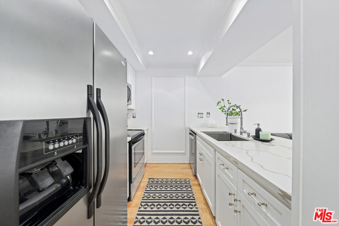 750 North Kings Road, Unit 204 Los Angeles, CA 90069 - Photo 14 of 23 a kitchen with a sink and white cabinets