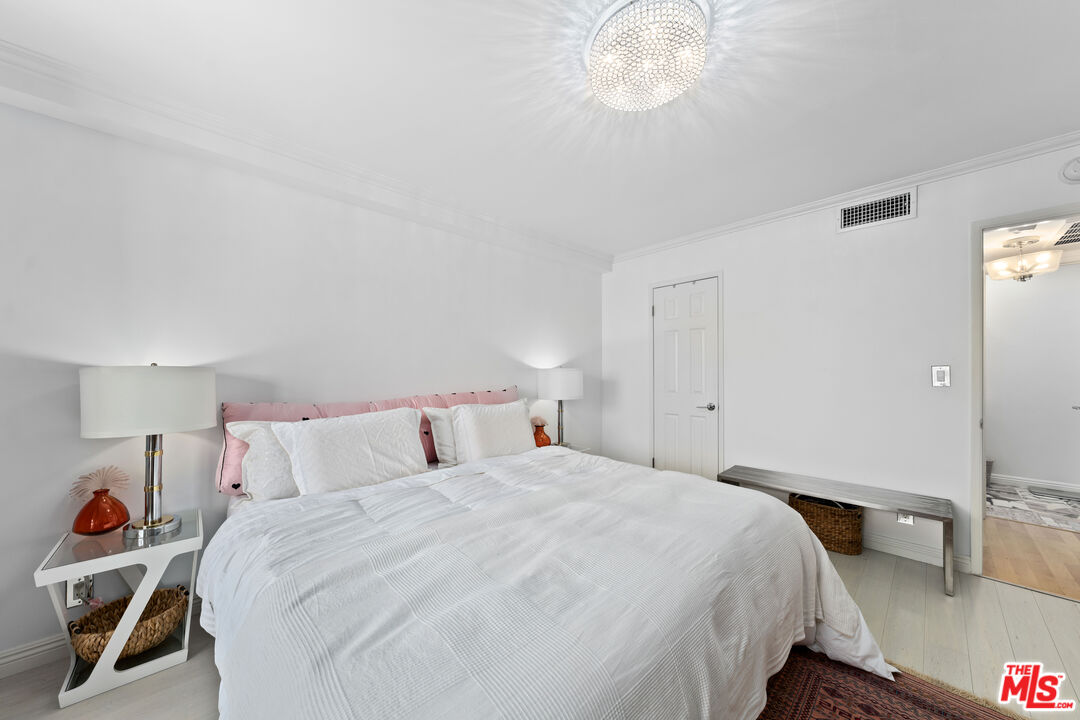 750 North Kings Road, Unit 204 Los Angeles, CA 90069 - Photo 16 of 23 a bedroom with a bed and a chandelier