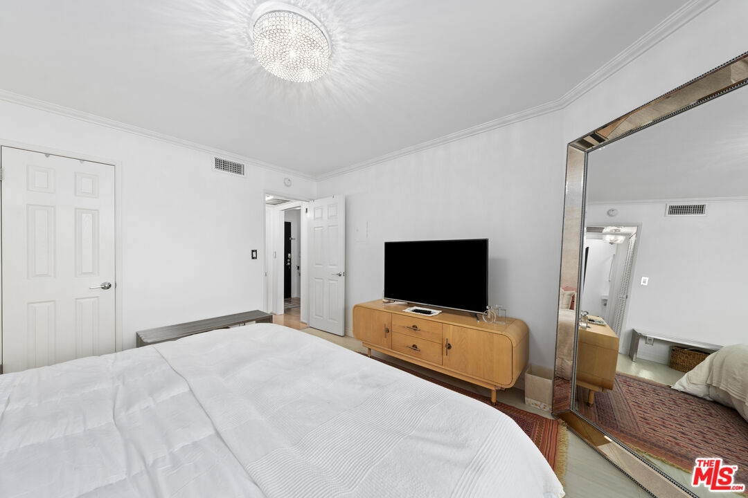 750 North Kings Road, Unit 204 Los Angeles, CA 90069 - Photo 17 of 23 a bedroom with bed and tv on desk
