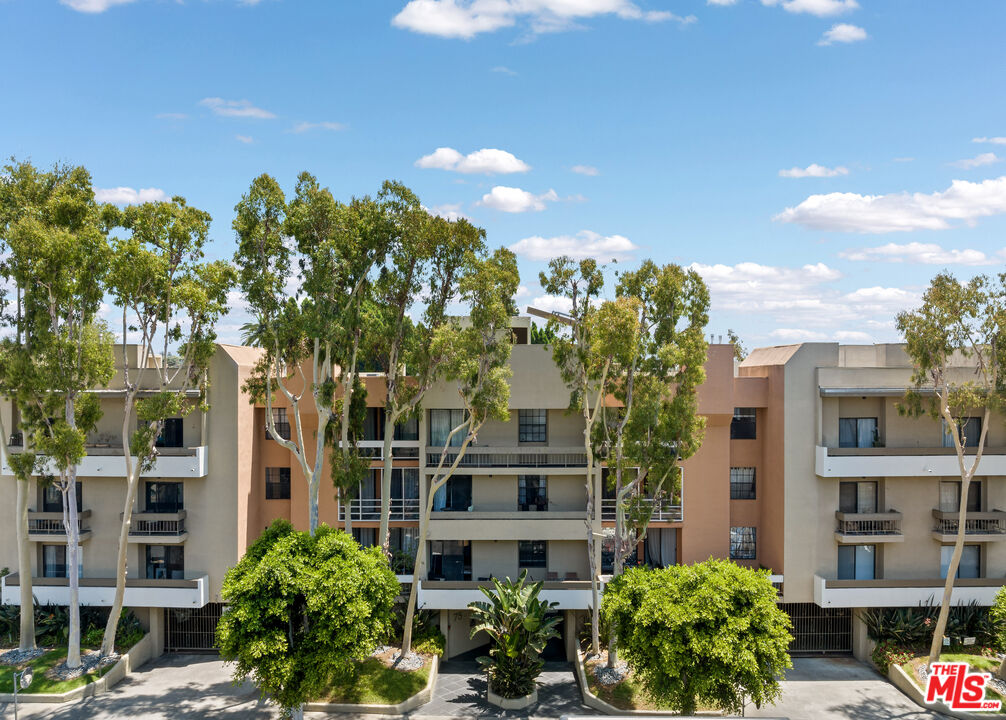 750 North Kings Road, Unit 204 Los Angeles, CA 90069 - Photo 2 of 23 a front view of a multi story residential apartment building with a yard and outdoor seating