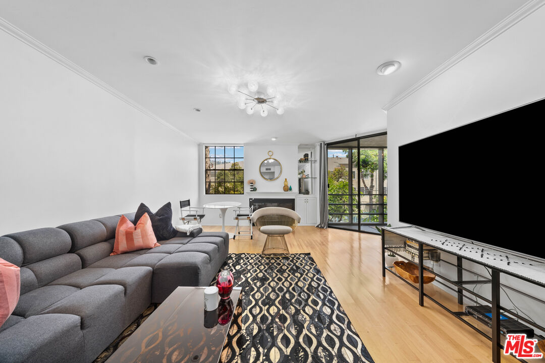 750 North Kings Road, Unit 204 Los Angeles, CA 90069 - Photo 5 of 23 a bedroom with furniture and a flat screen tv
