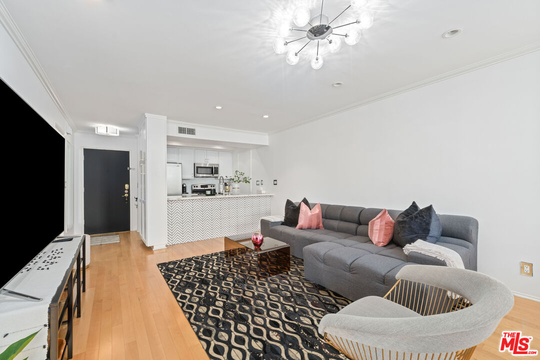 750 North Kings Road, Unit 204 Los Angeles, CA 90069 - Photo 6 of 23 a living room with furniture and a flat screen tv