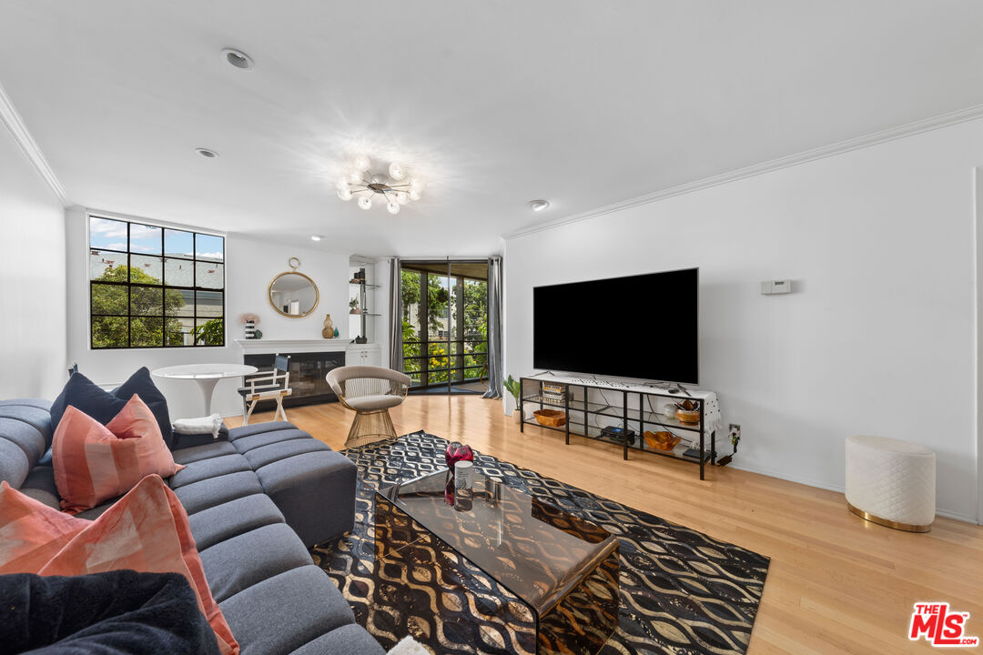 750 North Kings Road, Unit 204 Los Angeles, CA 90069 - Photo 8 of 23 a living room with furniture and a flat screen tv