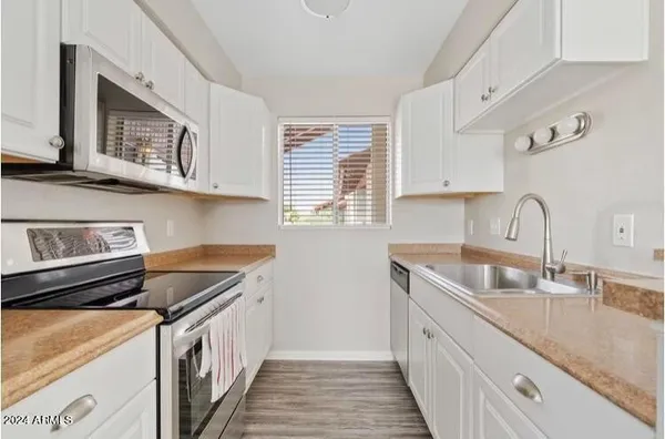 a kitchen with stainless steel appliances granite countertop a sink stove and cabinets