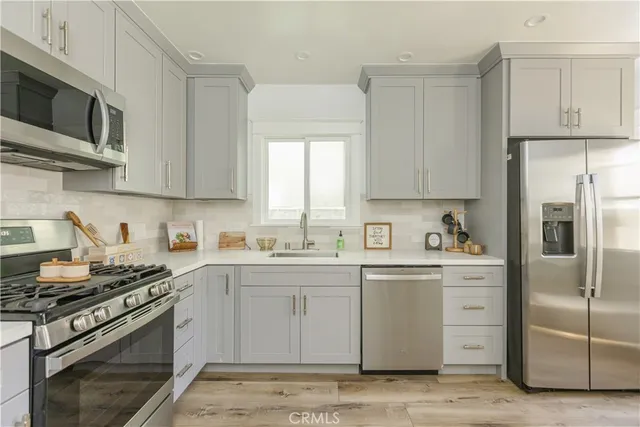 a kitchen with stainless steel appliances granite countertop a stove a sink dishwasher and a refrigerator