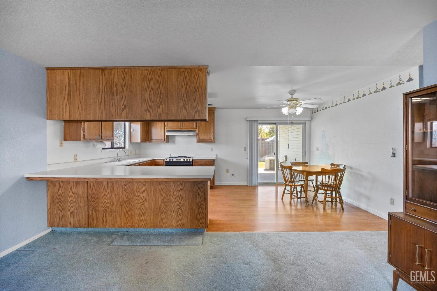Undisclosed Address Chowchilla, CA 93610 - Photo 10 of 29 a kitchen with stainless steel appliances granite countertop a stove top oven a sink a dining table and chairs with wooden floor