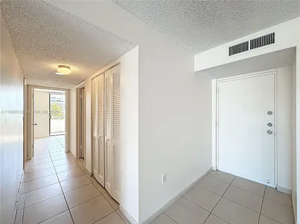 a kitchen with a refrigerator and white cabinets