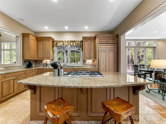 a kitchen with granite countertop a stove a sink and a refrigerator