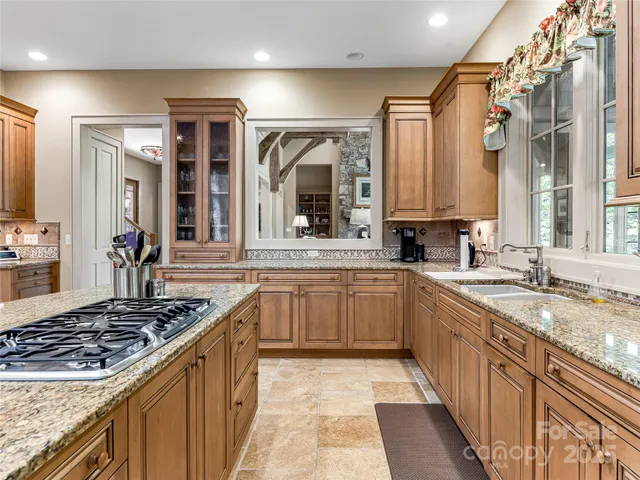 a kitchen with stainless steel appliances granite countertop a sink stove and cabinets