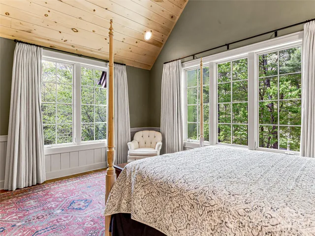 a bedroom with a large bed and a large window