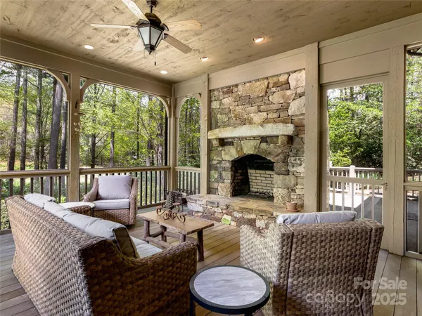 a living room with furniture a fireplace and a floor to ceiling window