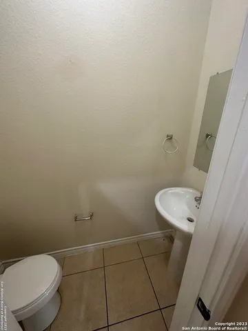 a white toilet sitting next to a white sink and vanity