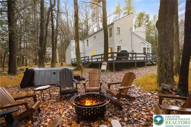a view of a lake with couches chairs and a fire pit