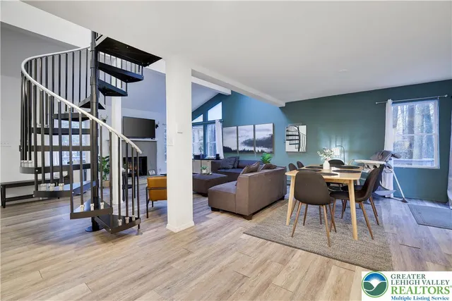 a living room with furniture stairs and a wooden floor