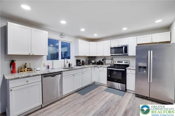 a kitchen with stainless steel appliances granite countertop a refrigerator and a stove top oven