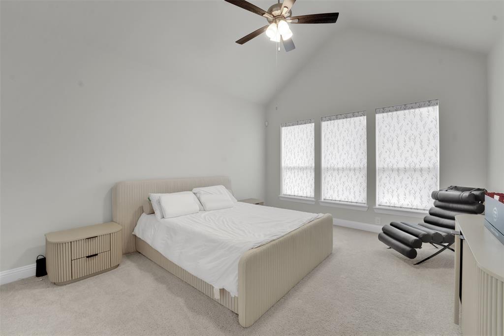 3520 Helios Lane Corinth, TX 76208 - Photo 16 of 37 Spacious room featuring vaulted ceilings, light-colored carpeting, and three windows with roller shades