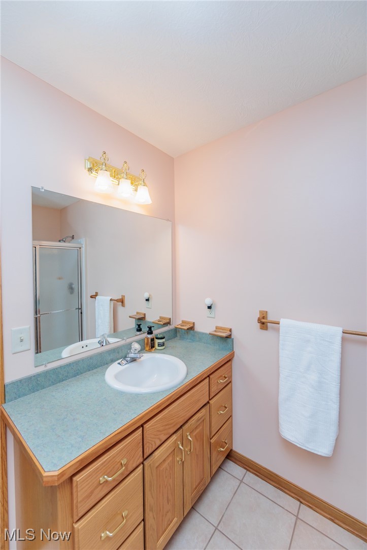 36556 Mills Road Avon, OH 44011 - Photo 26 of 36 Bathroom featuring tile patterned floors, walk in shower, and vanity