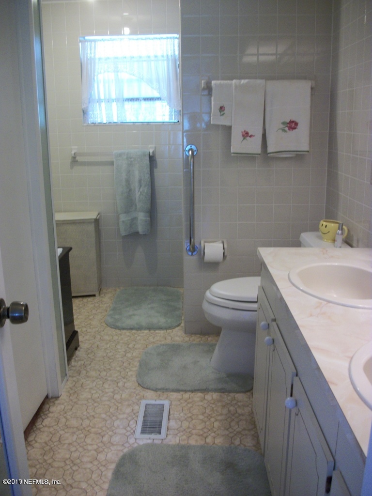 2855 Parrish Cemetery Road Jacksonville, FL 32221 - Photo 14 of 16 a bathroom with a granite countertop sink a toilet and a shower