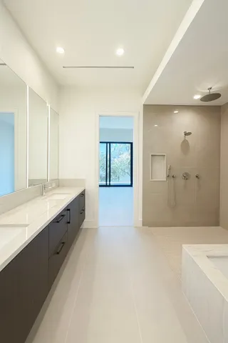 a large bathroom with a granite countertop sink a toilet a large mirror a bathtub and shower