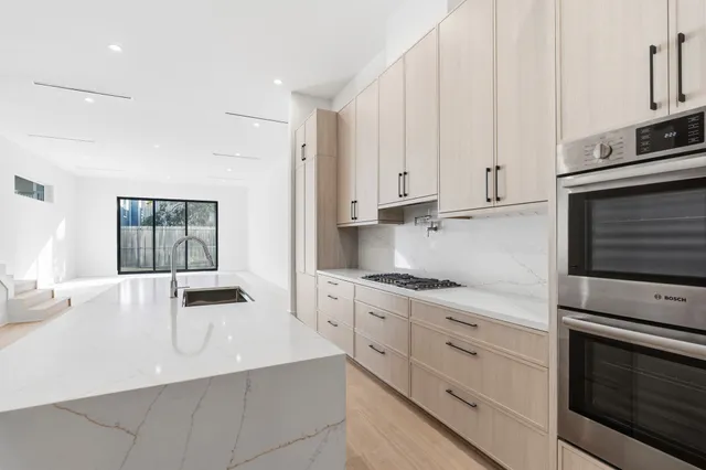a kitchen with granite countertop white cabinets and stainless steel appliances