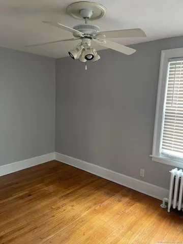 a view of a room with a window and wooden floor