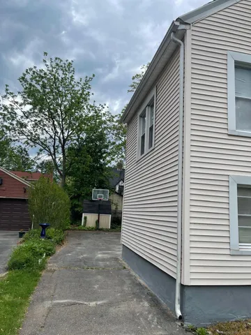 a view of a white house with a yard and a table and chair
