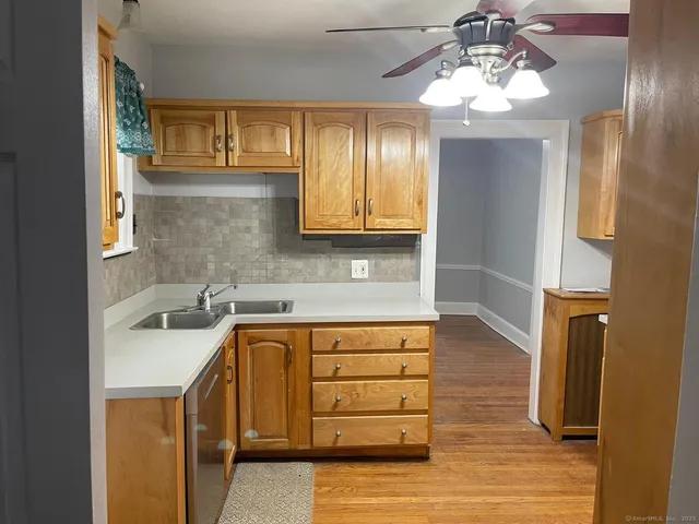 a kitchen with a sink cabinets and wooden floor