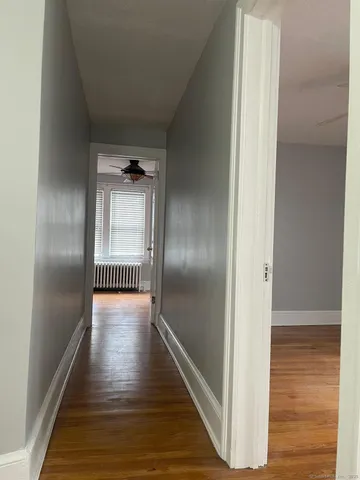 a view of a hallway with wooden floor