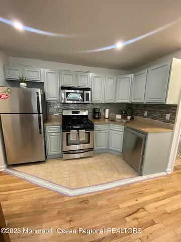 a kitchen with wooden cabinets and stainless steel appliances