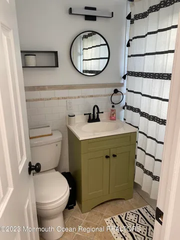 a bathroom with a toilet a sink and a mirror