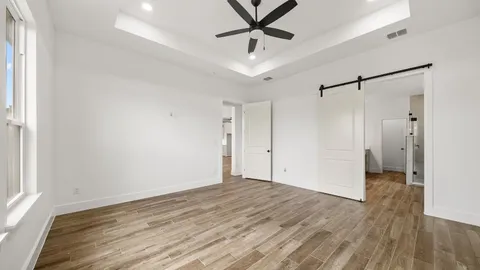 a view of a room with wooden floor and a ceiling fan