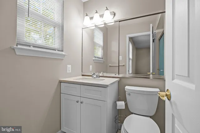 a bathroom with a toilet a sink and mirror