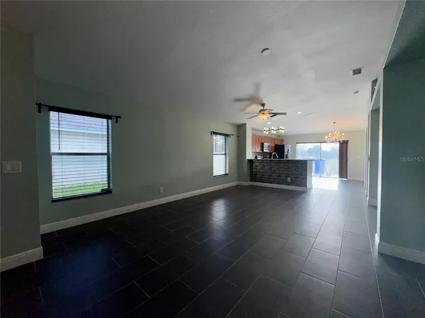 an empty room with windows and fireplace