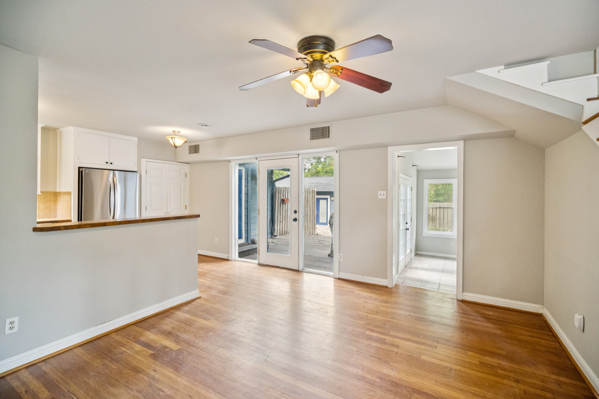 1402 Laurel Street, Unit B Georgetown, TX 78626 - Photo 5 of 21 Unfurnished living room featuring light wood finished floors, a ceiling fan, and stairs