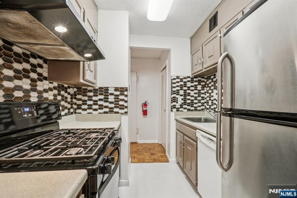 150 Overlook Avenue, Unit 6H Hackensack, NJ 07601 - Photo 17 of 29 a kitchen with white cabinets and appliances
