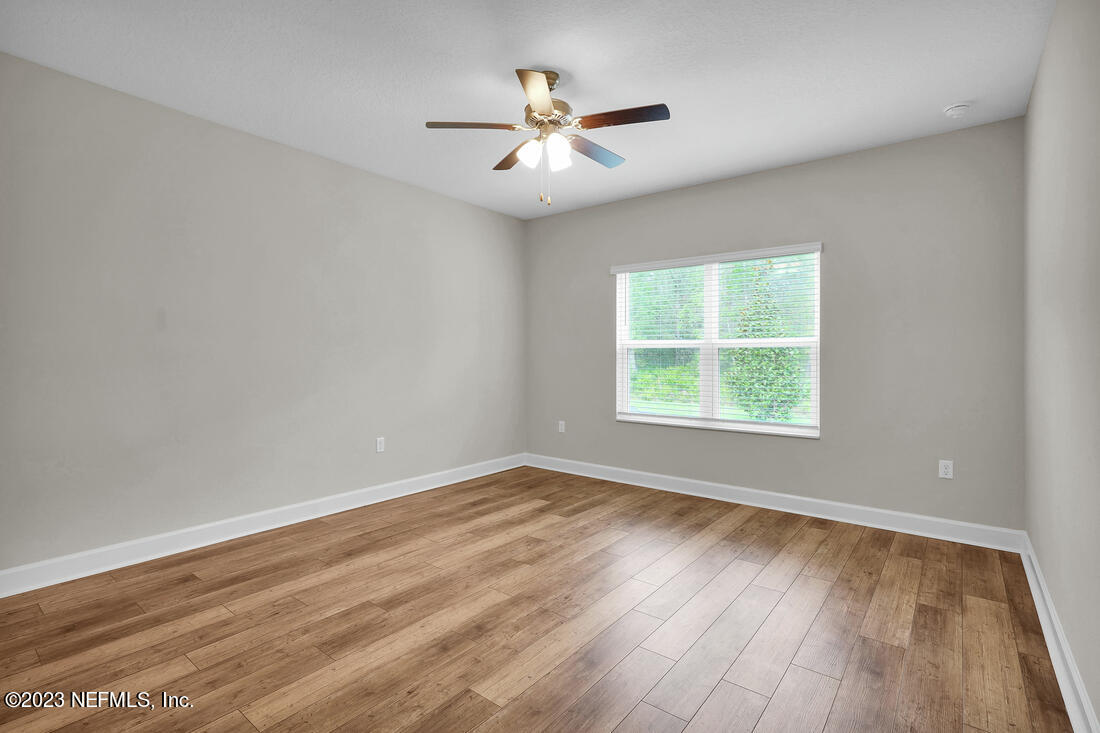 748 Morgans Treasure Road St. Augustine, FL 32084 - Photo 7 of 10 an empty room with wooden floor and windows