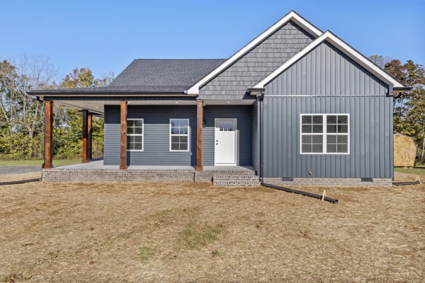 a view of a house with a yard and large tree