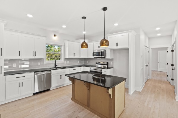 1030 Hanestown Road Lafayette, TN 37083 - Photo 16 of 48 a kitchen with stainless steel appliances granite countertop a sink a stove a refrigerator and white cabinets with wooden floor
