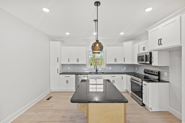 1030 Hanestown Road Lafayette, TN 37083 - Photo 17 of 48 a kitchen with stainless steel appliances granite countertop a sink a stove a refrigerator and white cabinets