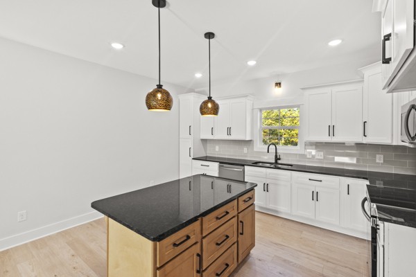 1030 Hanestown Road Lafayette, TN 37083 - Photo 18 of 48 a kitchen with kitchen island granite countertop a sink a counter space appliances and cabinets