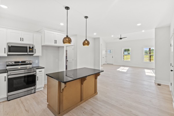 1030 Hanestown Road Lafayette, TN 37083 - Photo 20 of 48 a kitchen with stainless steel appliances granite countertop a stove a sink and a wooden floors