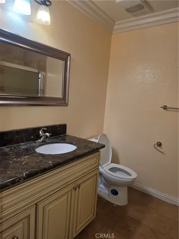 a bathroom with a granite countertop sink and a toilet