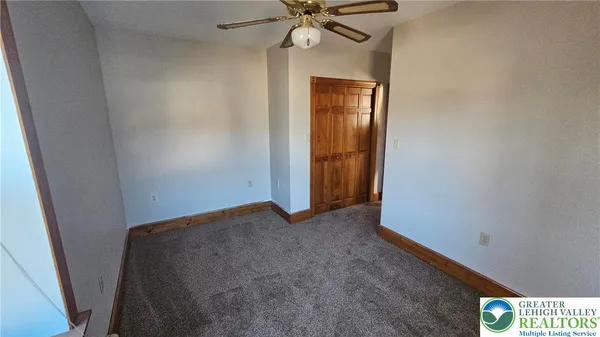an empty room with a ceiling fan and closet