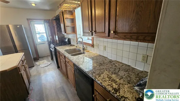 a kitchen with granite countertop a sink stove and cabinets