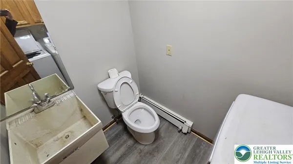 a bathroom with a granite countertop toilet and a sink