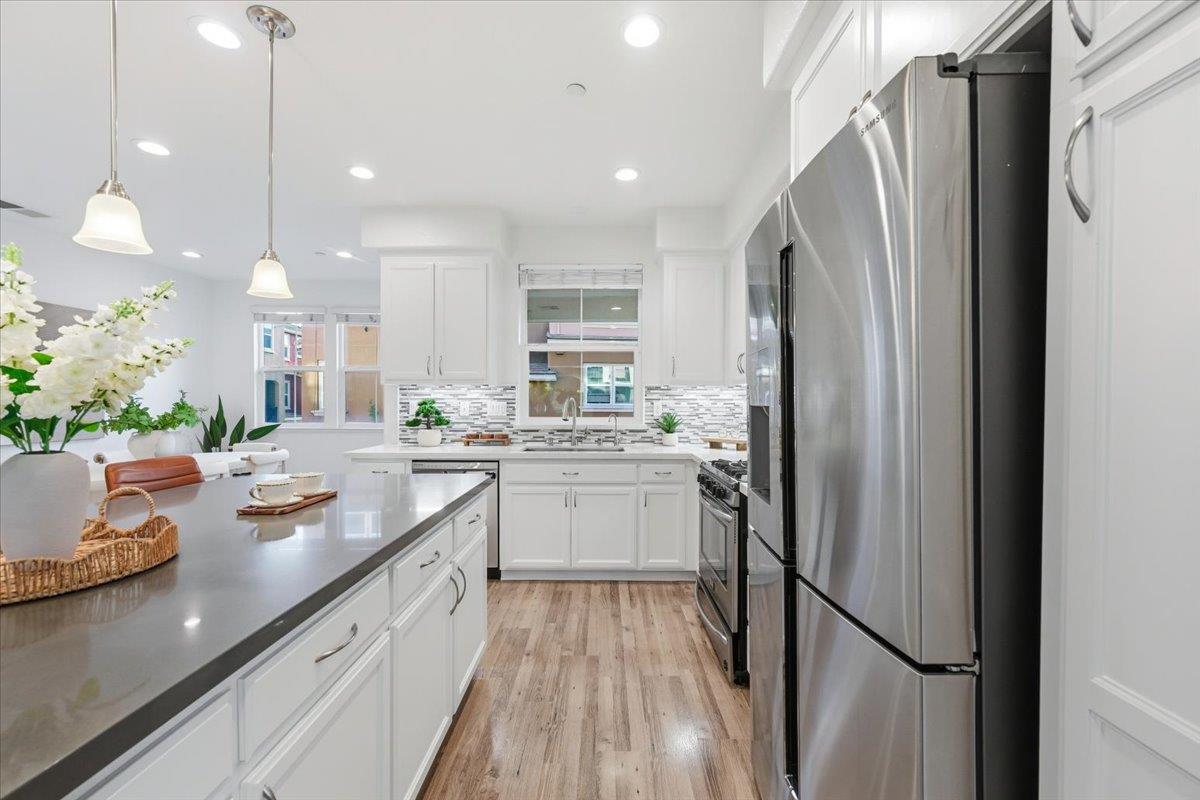 5614 Oceanspray Road Newark, CA 94560 - Photo 14 of 52 a kitchen with white cabinets and stainless steel appliances