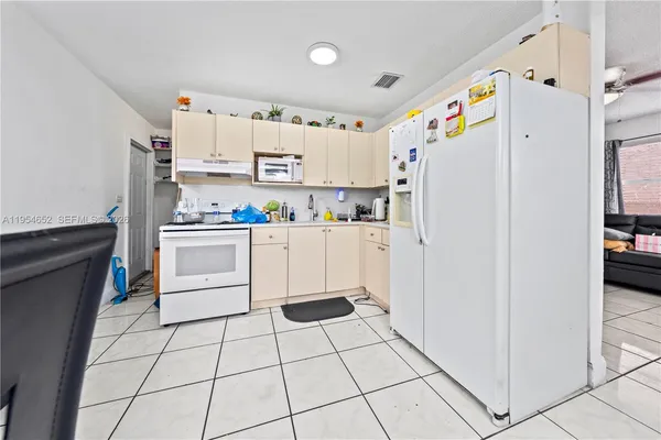 a kitchen with white cabinets and white appliances