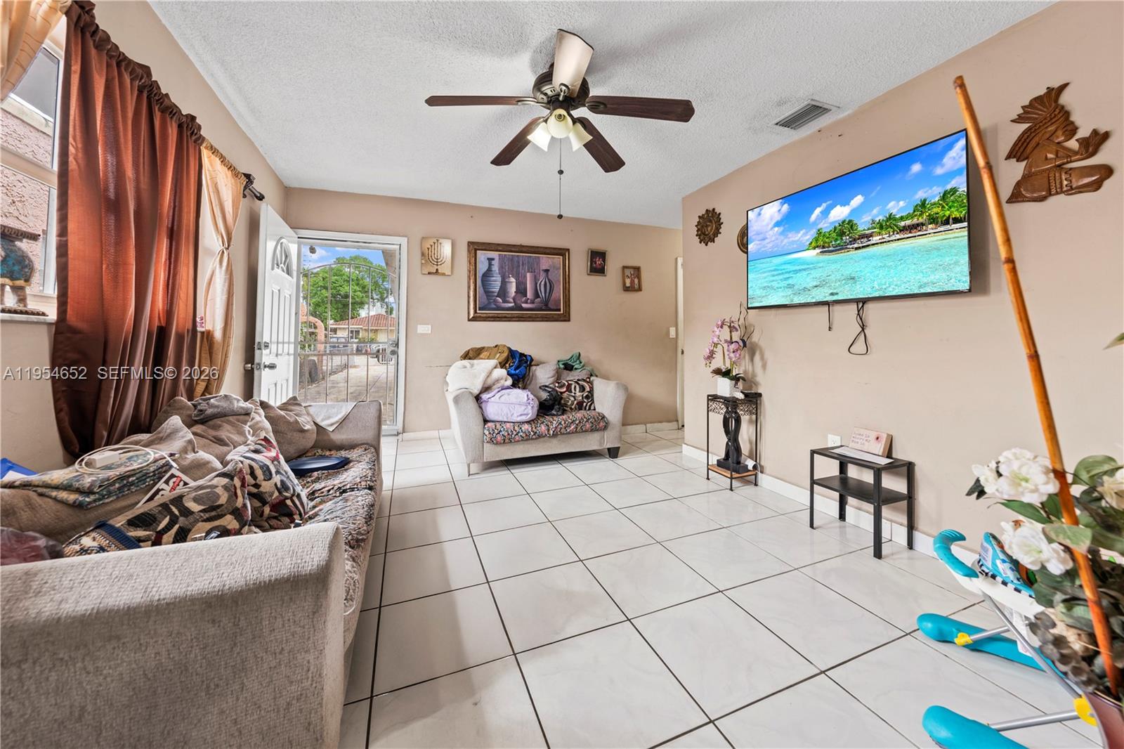 2110 Northwest 34th Street Miami, FL 33142 - Photo 19 of 33 a living room with furniture and a flat screen tv