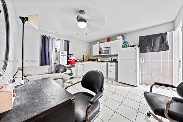 a living room with furniture a clock and a flat screen tv